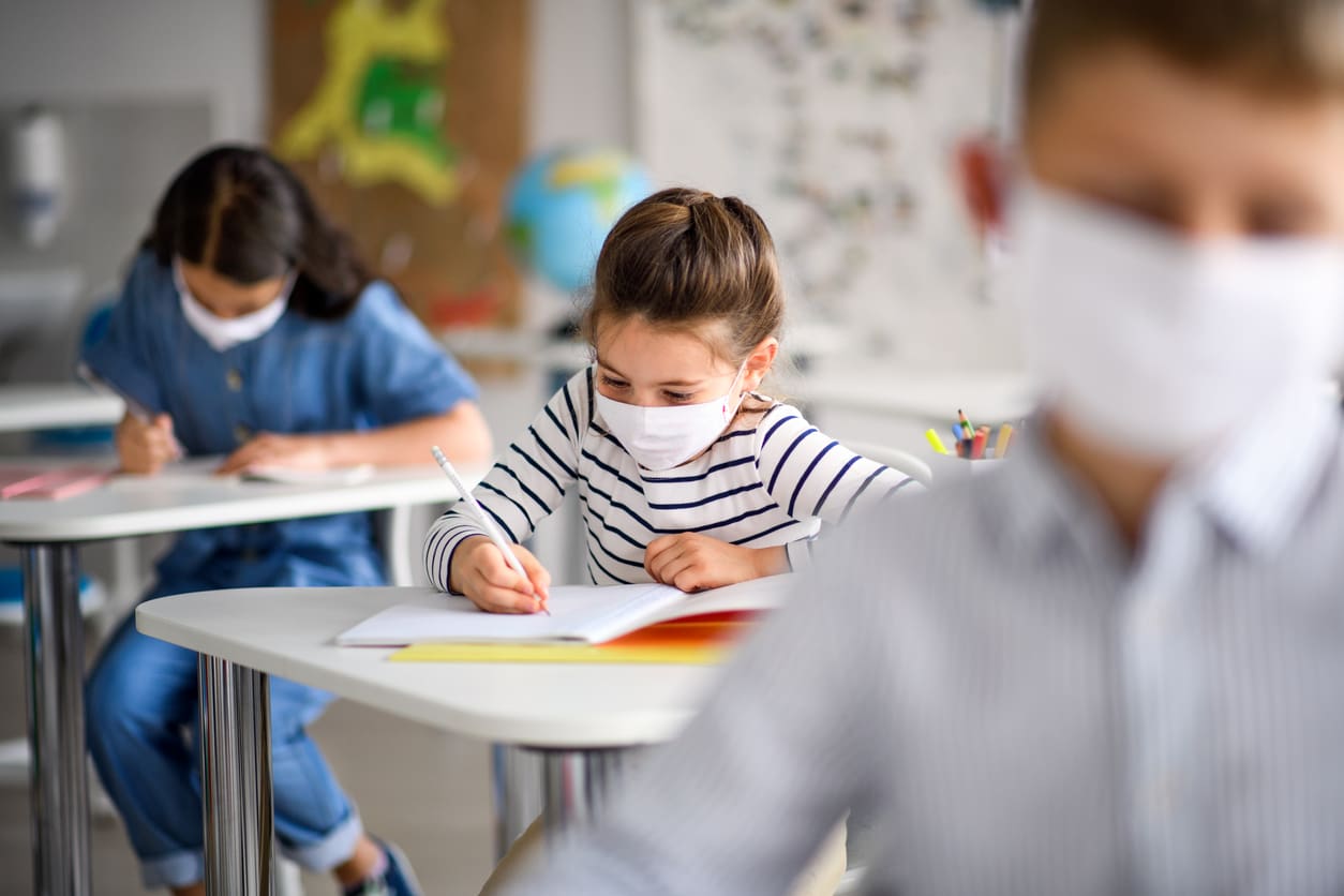 Children with face mask back at school after covid 19 quarantine and lockdown