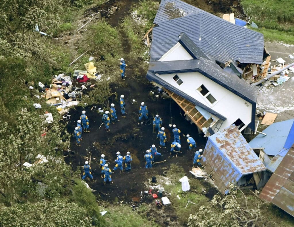 Police officers search for survivors from a house damaged by a landslide caused by an earthquake in atsuma town